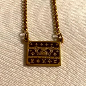 Louis Vuitton logo trunk charm on a necklace in gold